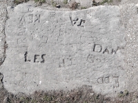 Autograph rock: Les, TP,  Dan, Edd, Kev, JA, RM, Steve, Jerry, Gord, Go, with circles and possible profile, DE, Judy G. + Eddie K. Chicago lakefront stone carvings, Calumet Park. 2024