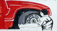 Stoic mechanic works on a wheel, Elmo's Tire Shop, Montrose Avenue at Avers. Elmo's retired this sign long ago.